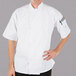 A man wearing a Mercer Culinary white chef jacket with short sleeves.