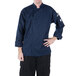A man wearing a Mercer Culinary Millennia navy blue chef coat.