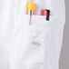 A white Mercer Culinary Millennia Air long sleeve chef jacket with a mesh back and a pocket with pens.