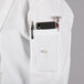 A person wearing a white Mercer Culinary chef coat with a phone and pen in the pocket.