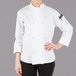 A woman wearing a white Mercer Culinary chef coat with cloth knot buttons.