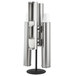 A Vollrath stainless steel cup dispenser stand with three white cups on it.