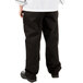 A person wearing Mercer Culinary black chef pants and a white shirt.