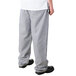 The lower half of a person wearing Mercer Culinary houndstooth chef pants.