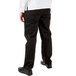 The lower body of a person wearing Mercer Culinary Millennia women's black chef pants.