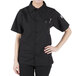 A woman wearing a black Mercer Culinary cook shirt with mesh back.