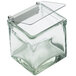 A Cal-Mil clear glass container with a solid plastic lid and stainless steel hinge on a table.
