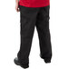 A person wearing Mercer Culinary Genesis black cargo pants.