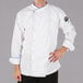 A man wearing a Mercer white chef jacket with royal blue piping.