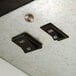 A close-up of two black switches on a metal surface.
