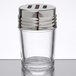 A clear glass American Metalcraft spice shaker with a stainless steel top with slotted holes.