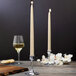 Two Sterno ivory taper candles on a table.