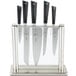 A Mercer Culinary Z&#252;M&#174; knife set in a glass and stainless steel holder.