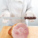 A chef using a Victorinox rosewood handled serrated carving knife to slice ham.