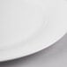 A close-up of a white Reserve by Libbey bone china round plate with a white rim.