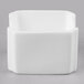 A white square bone china sugar packet holder with a lid on a gray surface.