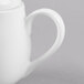 A close-up of a white bone china teapot with a lid on a white surface.