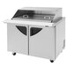 A Turbo Air stainless steel refrigerated sandwich prep table with sliding lids over food pans.