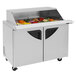 A Turbo Air stainless steel refrigerated sandwich prep table with sliding lids open to reveal food.