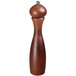 A Fletchers' Mill Marsala walnut stain pepper mill with a silver top on a table in a home kitchen.