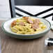 A Dinex insulated meal delivery base with a plate of pasta with sausages on it.