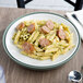 A Dinex insulated meal delivery base with a plate of pasta with sausages and pesto sauce.