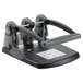 A black and grey Swingline 3 hole punch on a table.