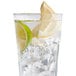 A glass of water with ice and a lemon wedge on a white background.