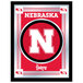A rectangular mirror with a red and black University of Nebraska Huskers logo.