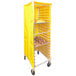A yellow Curtron bun pan rack cover on a bun pan rack with trays of bread.