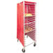A red Curtron bun pan rack cover on a rolling rack with food on it.