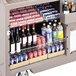 A Cambro wire shelf holding bottles and cans of beverages.