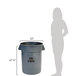 A woman standing next to a grey Rubbermaid Brute commercial trash can.