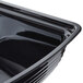 A black plastic Cambro rectangular ribbed bowl with a lid on a counter.