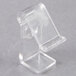 A clear plastic Snap Drape T clip on a white surface.