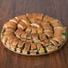 A Solut natural coated corrugated catering tray holding sandwiches on a table.