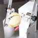 A peeled apple being cut into a tourne shape with a Tellier manual vegetable cutter.