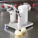 A Tellier MLT manual tourne vegetable cutter on a table with a peeled potato in it.