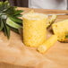 A pineapple is cut into a cylinder using a Tellier pineapple corer.