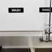 A sink with a Vollrath Traex rinse sign and a wash sign above it.