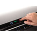 A hand pressing a button on a Fellowes Jupiter 2 laminator.