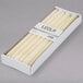 A box of Hyoola ivory wax taper candles.