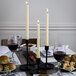 A table set with food and Hyoola ivory taper candles.