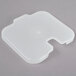 A white plastic container lid with a piece of plastic inside.