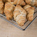 Clipper Mill by GET chrome plated iron square wire basket with a group of croissants on a metal rack.