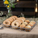 A tray of bagels and muffins in a Clipper Mill gray iron wire pastry basket.