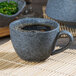 A 10 Strawberry Street Biseki blue stoneware cup of coffee on a table.