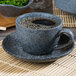 A blue 10 Strawberry Street Biseki stoneware cup of coffee on a saucer.