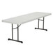 A white rectangular Lifetime professional-grade plastic folding table with black metal legs.