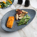 A 10 Strawberry Street Biseki blue stoneware platter with salmon, green beans, and potatoes on a marble table with a fork.